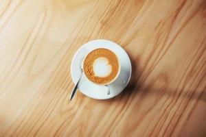 café cappuccino de arte no fundo da mesa de madeira foto