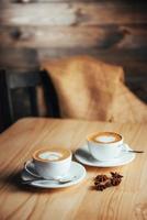 duas xícaras de cappuccino gourmet da casa de café foto