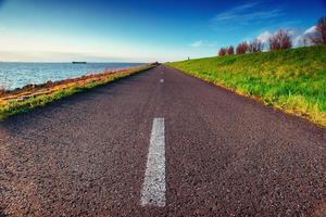 estrada de asfalto ao longo do mar em um dia de verão fantástico foto