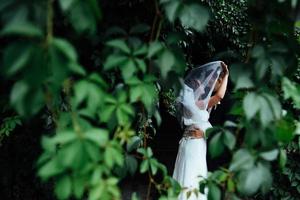 lindo jovem casal de noivos beijando, noiva loira com flowe foto