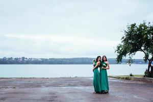 mulheres jovens felizes em um casamento com buquês de flores foto