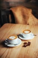 duas xícaras de cappuccino gourmet da casa de café foto