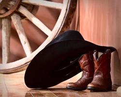 chapéu de cowboy apoiado em botas foto