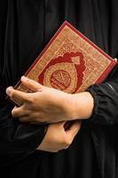 alcorão na mão livro sagrado dos muçulmanos item público de todos os muçulmanos alcorão na mão muçulmana mulher foto