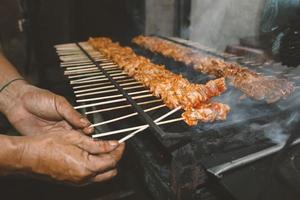 satay de frango ou satay de pele de frango é espetos de frango grelhados marinados com especiarias e molho de pimenta vermelha foto