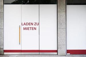 sinal de vaga alemão na vitrine - carregado zu mieten significa loja para deixar foto