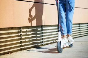 mulher circulando na cidade com uma scooter elétrica foto