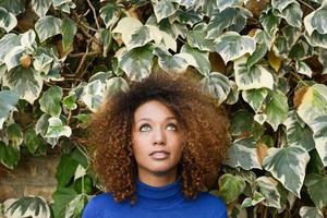 jovem com penteado afro em meio urbano foto