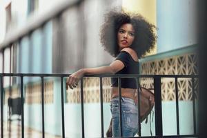 jovem mulher mista com cabelo afro em pé na rua foto