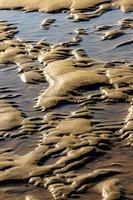 areia após a maré baixa em uma praia na cantábria, espanha. imagem vertical. foto