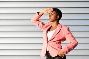 mulher negra, modelo de moda, de pé na parede urbana