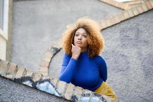 jovem com penteado afro em meio urbano foto