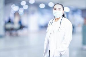 mulher médica fica na frente de uma sala de exames em um hospital. conceito de tratamento médico cuidados de saúde anual de beleza, pesquisa, laboratório, ciência, closeup, espaço de cópia, fundo desfocado foto