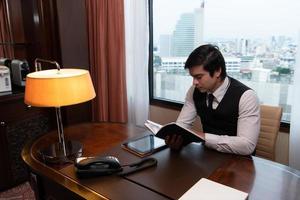 um jovem empresário monitora e acompanha as tarefas em seu escritório foto