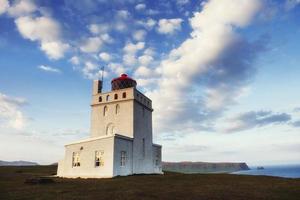 lindo farol branco no cabo dyrholaey, sul da islândia. foto