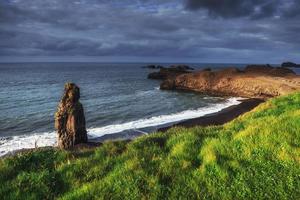 reynisfjara praia de areia preta na islândia. montanhas reynisfyal foto