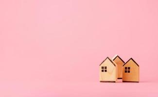 conceito de economia e investimento de dinheiro. casas de madeira em fundo rosa com espaço de cópia foto