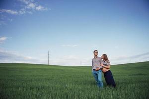 família feliz abraçando em um campo de trigo verde foto