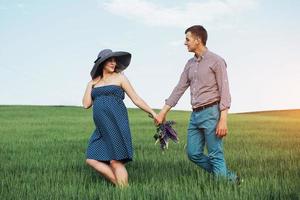 família feliz abraçando em um campo de trigo verde foto