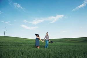 família feliz abraçando em um campo de trigo verde foto