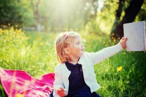 menina feliz em um piquenique de verão no parque. foto