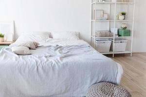 interior elegante do quarto loft. apartamento de design espaçoso com paredes claras grandes janelas cama grande. decoração moderna limpa com móveis elegantes em estilo escandinavo minimalista. foto