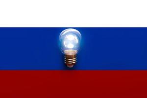 bandeira nacional da rússia com lâmpada. conceito de restrições de eletricidade e luz foto