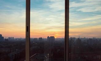 paisagem urbana de kyiv ao pôr do sol pela janela foto