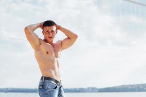 modelo masculino musculoso com corpo perfeito posando em jeans azul foto