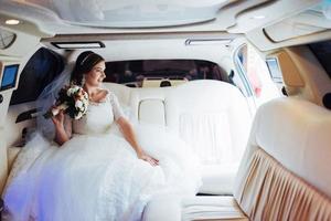 retrato de uma linda jovem noiva no carro foto