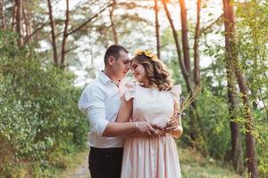 casal jovem feliz em uma floresta de pinheiros no verão foto