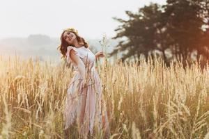 linda garota feliz em uma coroa de flores na cabeça foto