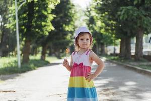 criança engraçada com pirulito de doces, menina feliz comendo grande foto