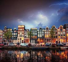 canal de amsterdã em belas nuvens cumulus e relâmpagos foto