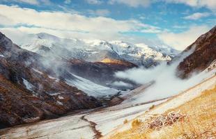 paisagem montanhosa de montanhas cobertas de neve na névoa foto