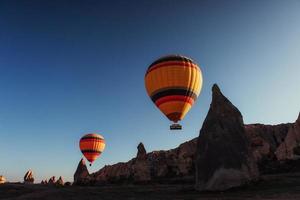 balão de ar quente sobrevoando a paisagem rochosa na Capadócia Turquia. foto