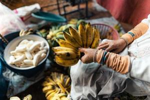 banana cultivada para processamento, banana na mão do vendedor foto