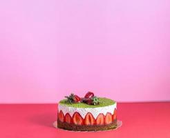 torta de morango e pistache sobre fundo colorido isolado com aparência mínima. espaço de cópia inclui. foto
