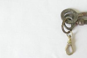 chaves de ferro velhas e chaveiro contra fundo branco foto