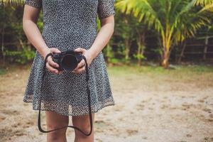 estilo de vida vintage jovem fotógrafo jovem mulher segurando uma lente da câmera. foto