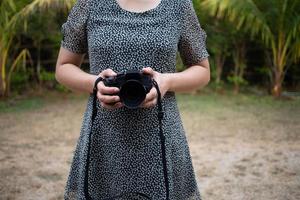 estilo de vida vintage jovem fotógrafo jovem mulher segurando uma lente da câmera. foto