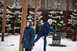 dois caras jogando bolas de neve em dia de inverno. foto