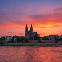 belo pôr do sol sangrento no centro histórico de magdeburg, cidade velha, rio elba e magnífica catedral, alemanha. foto