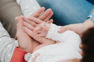 mamãe e papai seguram a mão do bebê. alça de criança foto