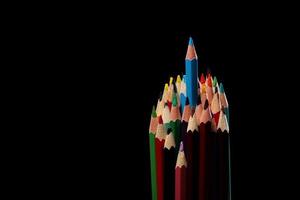 grupo de lápis de cor de cores diferentes, isolados em um fundo preto. cor azul puxada para cima. fechar-se foto