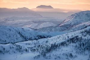 paisagem cordilheira nevada com céu colorido no pico foto