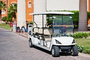 carro de golfe branco com banco traseiro no resort. foto