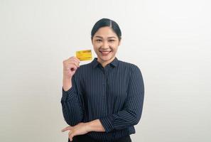 mulher asiática segurando um cartão de crédito com fundo branco foto
