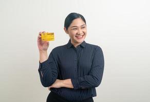 mulher asiática segurando um cartão de crédito com fundo branco foto