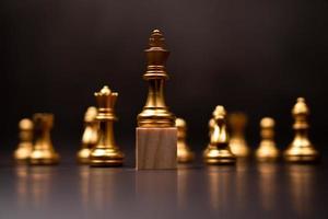xadrez rei dourado em pé em um suporte de madeira. o conceito de líderes em boas organizações deve ter visão e pode prever tendências de negócios e avaliar concorrentes foto